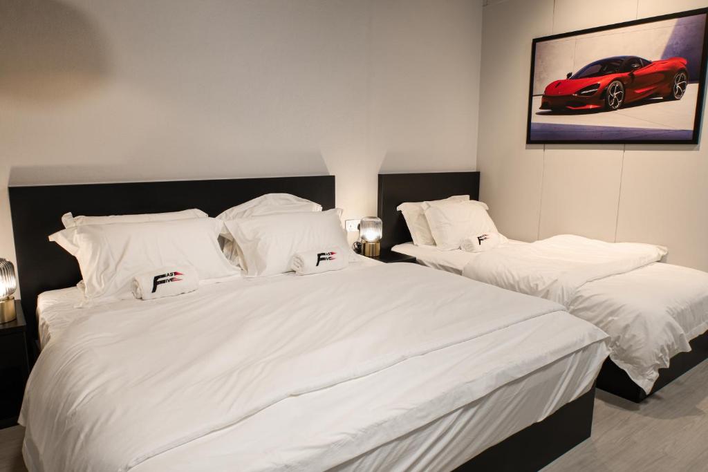 Tanjong Tokong的住宿－FAST FIVE At Gurney，一间卧室配有两张带白色床单和红色汽车的床。