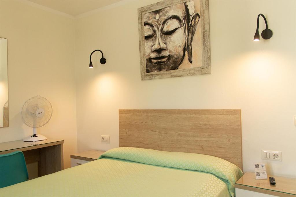 - une chambre avec un lit et une peinture murale dans l'établissement Hostal Magec, à Puerto del Carmen