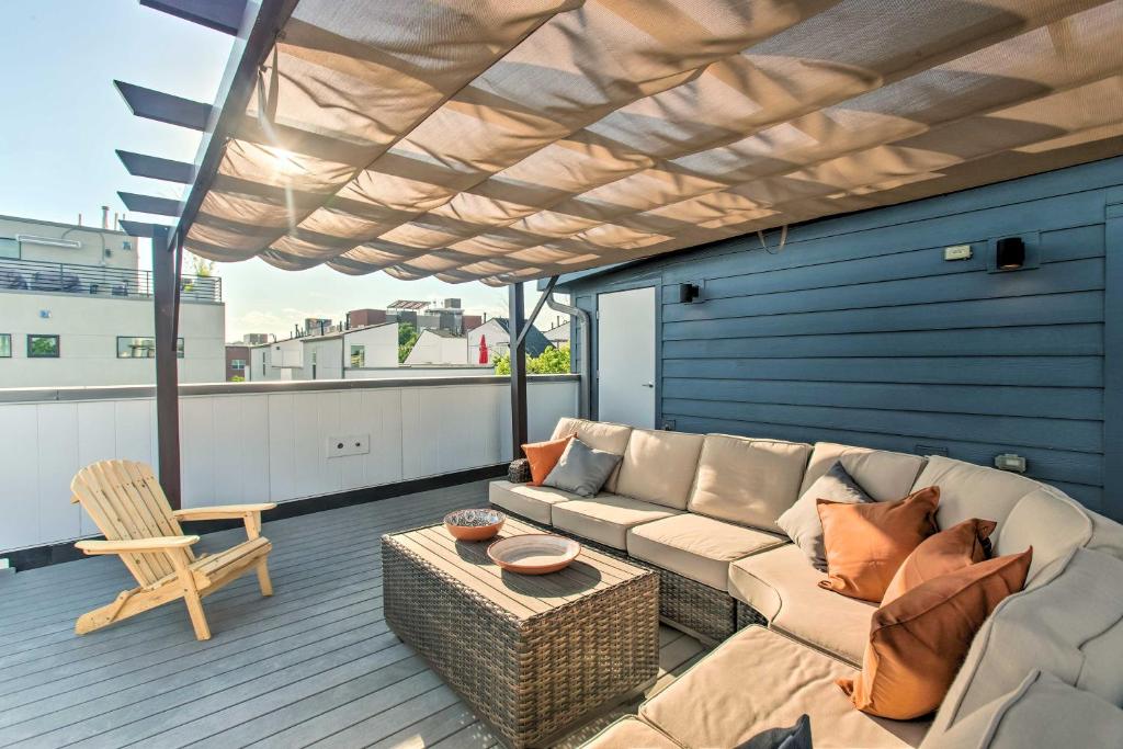 a living room with a couch and a chair on a deck at Modern Denver Townhome with Rooftop Terrace! in Denver