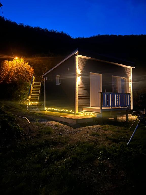 a house with lights on the side of it at night at Overnatting med sjøutsikt å rolige omgivelser in Alta