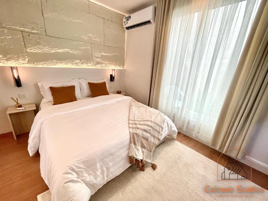 a bedroom with a white bed and a large window at Modern studio with self check-in in Riyadh