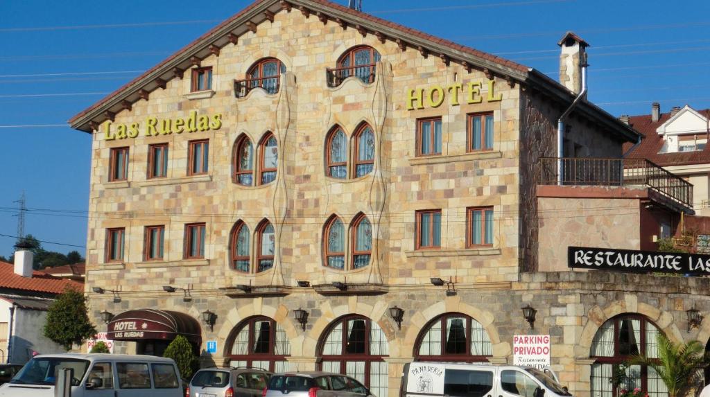 - un grand bâtiment en pierre avec un panneau d'hôtel dans l'établissement Hotel Las Ruedas, à Laredo