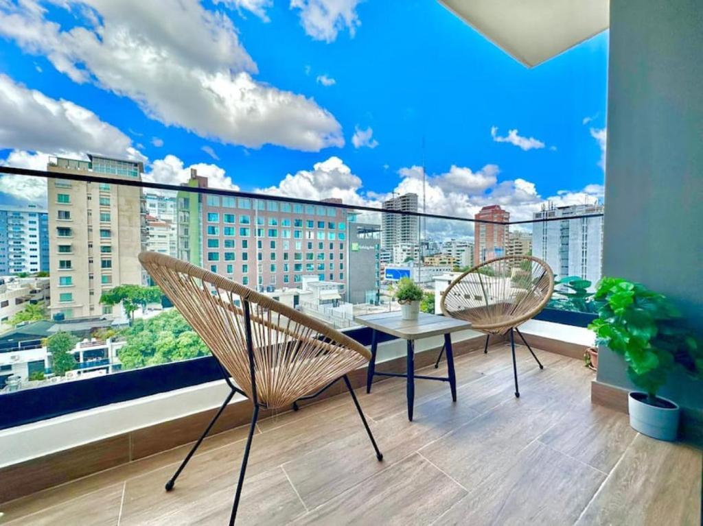 a balcony with a table and chairs and a large window at Stunning City Center Condo in Los Prados