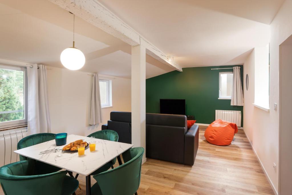 uma sala de estar com uma mesa e cadeiras verdes em Le T2 Chic ! em Carcassonne