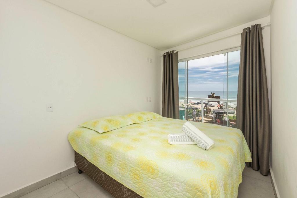 1 dormitorio con 1 cama con teclado y ventana en Sobrado frente ao mar Mariscal 4 Pessoas, en Bombinhas