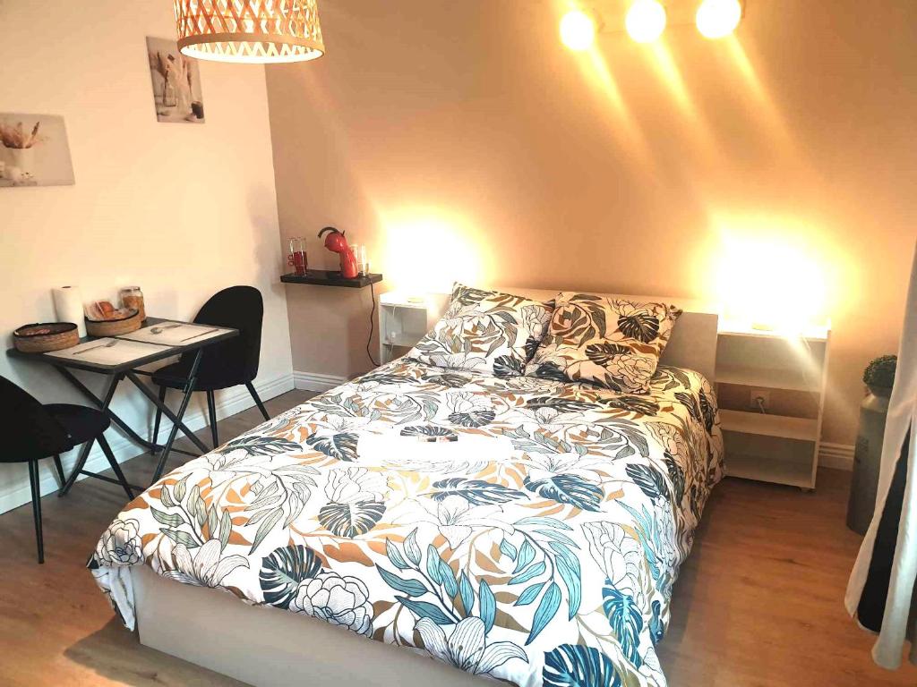 - une chambre avec un lit et une table avec des chaises dans l'établissement Chez Cerise, à Tournay