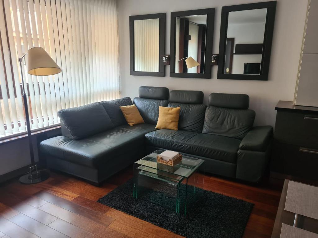 a living room with a blue couch and a table at Warta LUX Apartment, self check-in 24h, free parking in Poznań