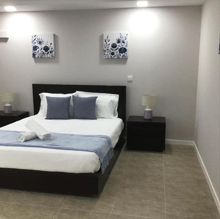 Oceanview Apartments في فيانا دو كاستيلو: غرفة نوم بسرير كبير مع مواقف ليلتين