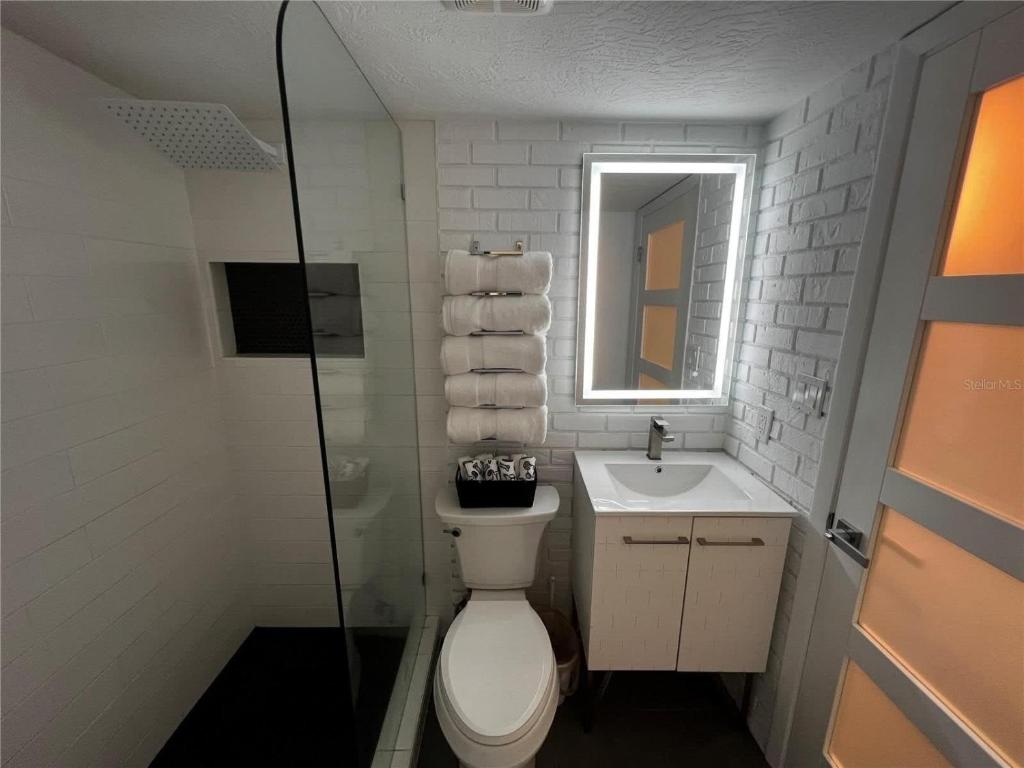 La salle de bains est pourvue de toilettes, d'un lavabo et d'un miroir. dans l'établissement Sapphire Shores- Oceanfront at Symphony Beach Club, à Ormond Beach