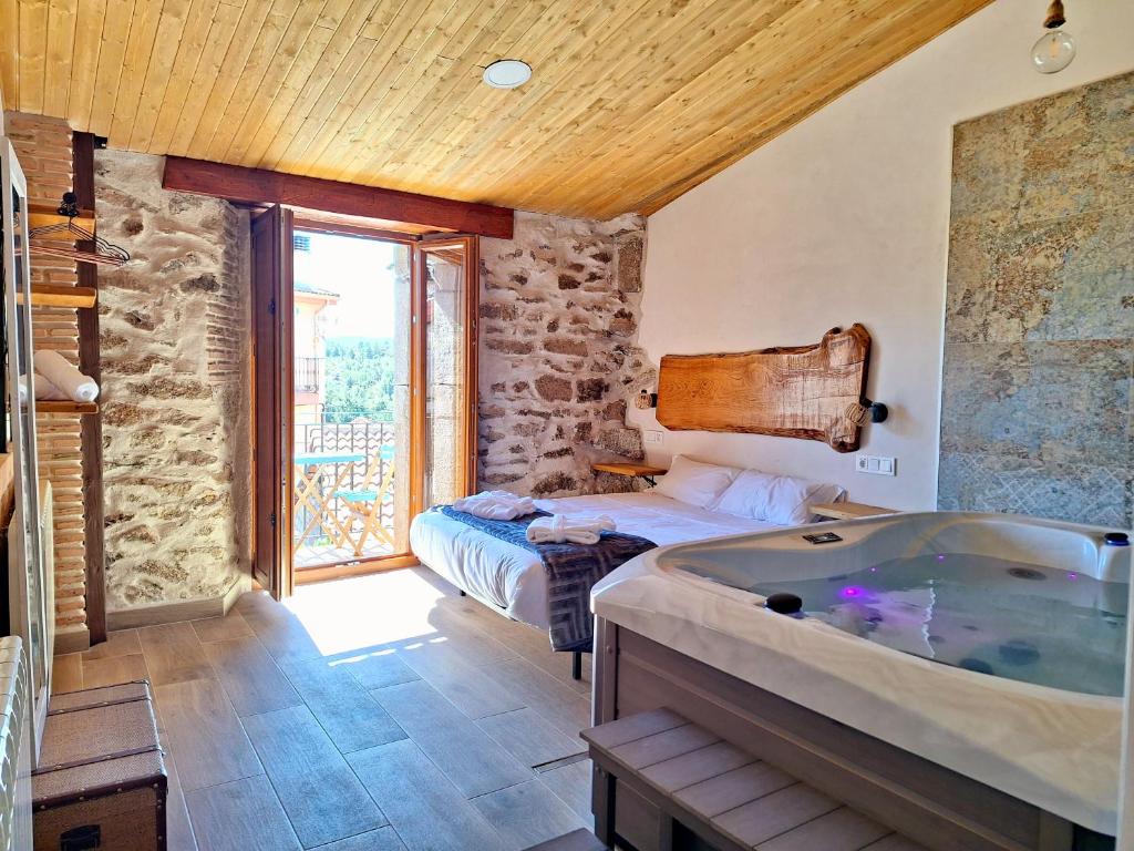 ein Bad mit einer Badewanne, einem Bett und einem Fenster in der Unterkunft El Hilo de los Sueños in Navatalgordo