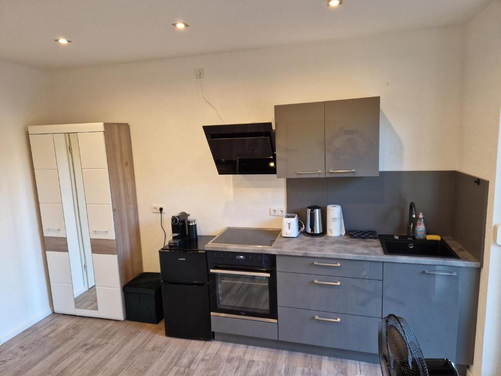 une cuisine avec un évier et une cuisinière dans l'établissement Ferienwohnung Schwarzwald friedhofstraße 13, à Obersasbach