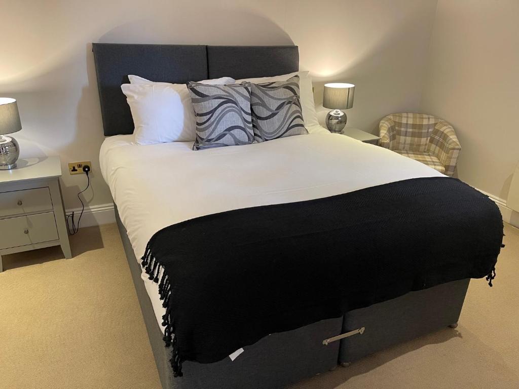 The Crown of Cookham في كوكهام: غرفة نوم بسرير كبير عليها شراشف ووسائد بيضاء