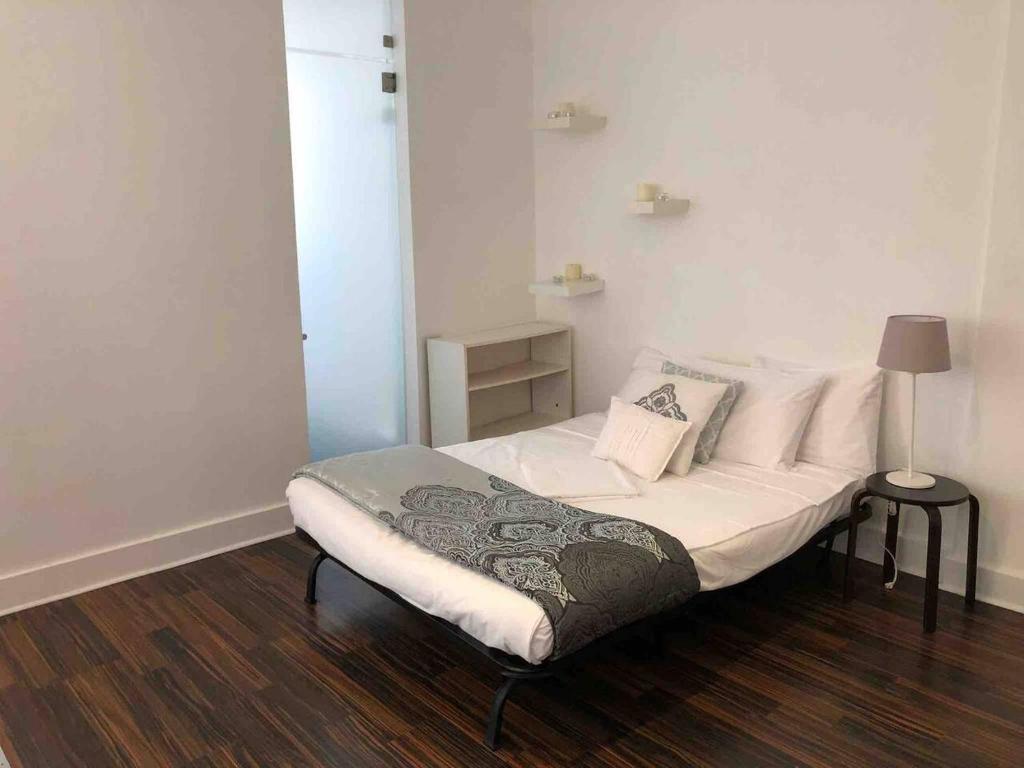 niewielka sypialnia z łóżkiem z białą pościelą i poduszkami w obiekcie Studio Miami beach w Miami Beach