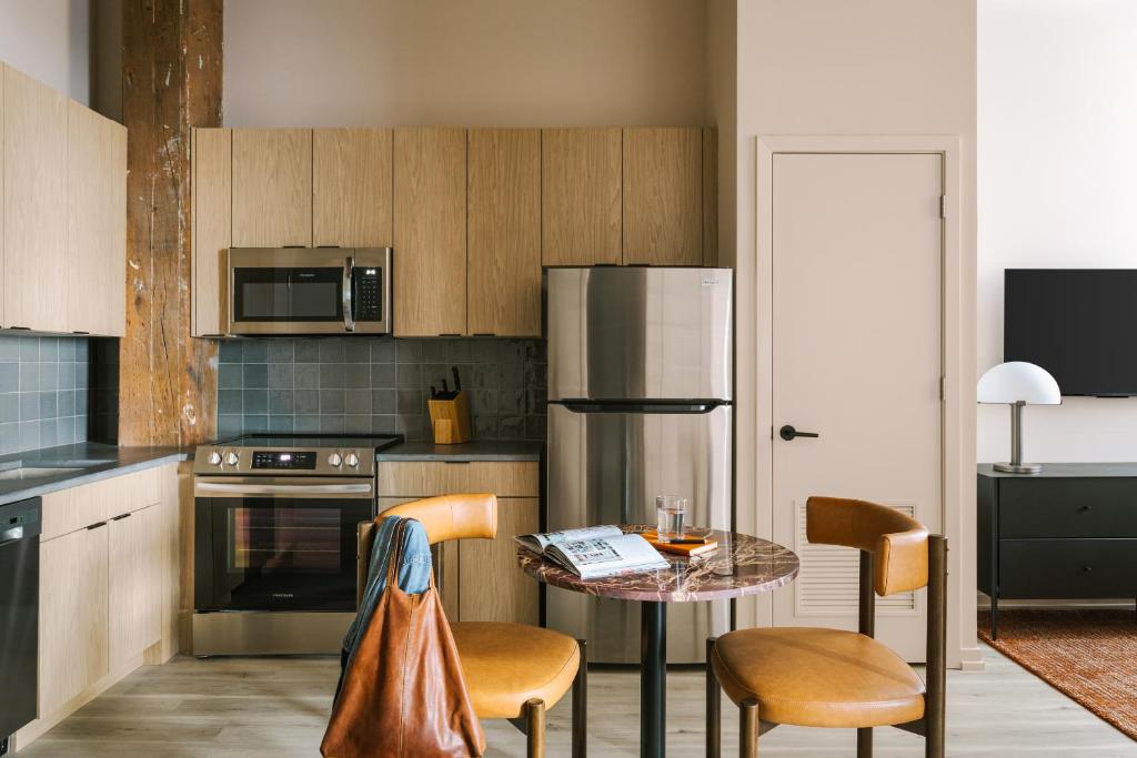 a kitchen with a table and a stainless steel refrigerator at Sonder The Burnham in Chicago