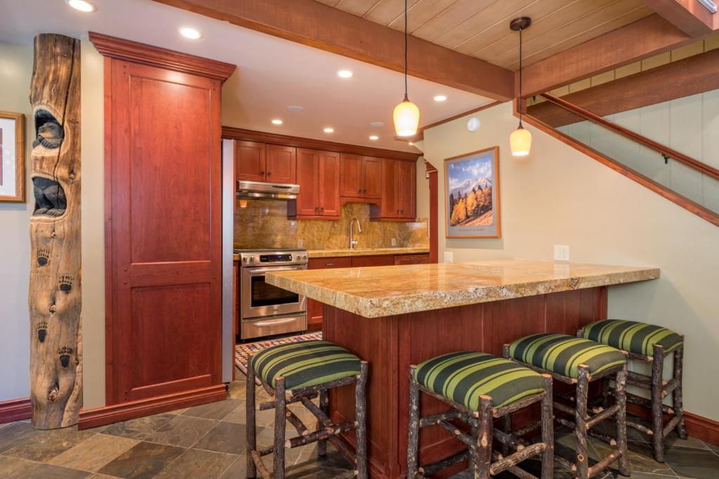 cocina con armarios de madera y barra con taburetes en Villager - 1220 at Sun Valley, en Sun Valley