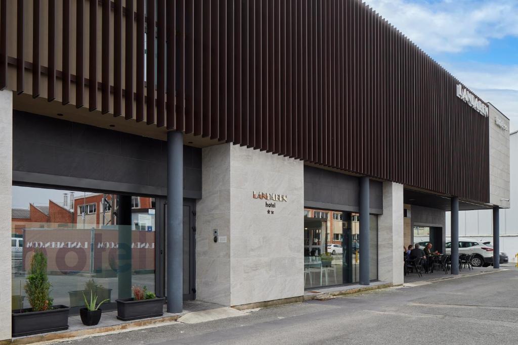 a store front of a building with a brown roof at Hotel Landaben in Pamplona