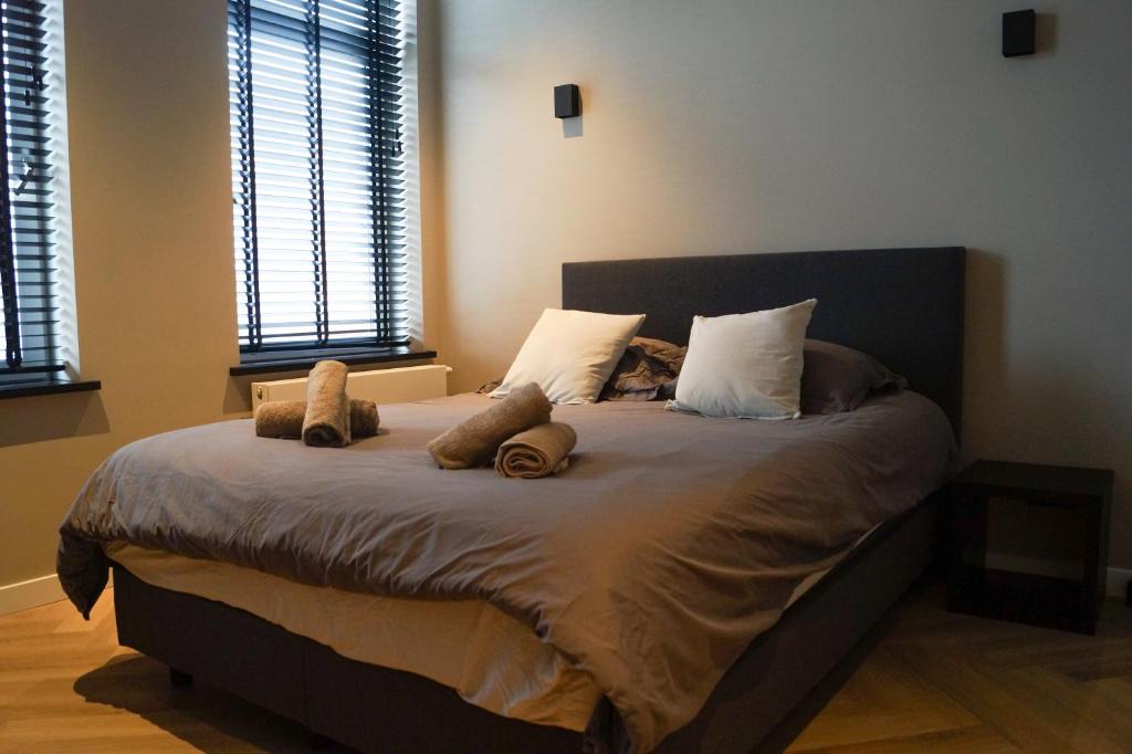 Un dormitorio con una cama con dos ositos de peluche. en Super de luxe privékamer op een toplocatie - Room 1, en Egmond aan Zee