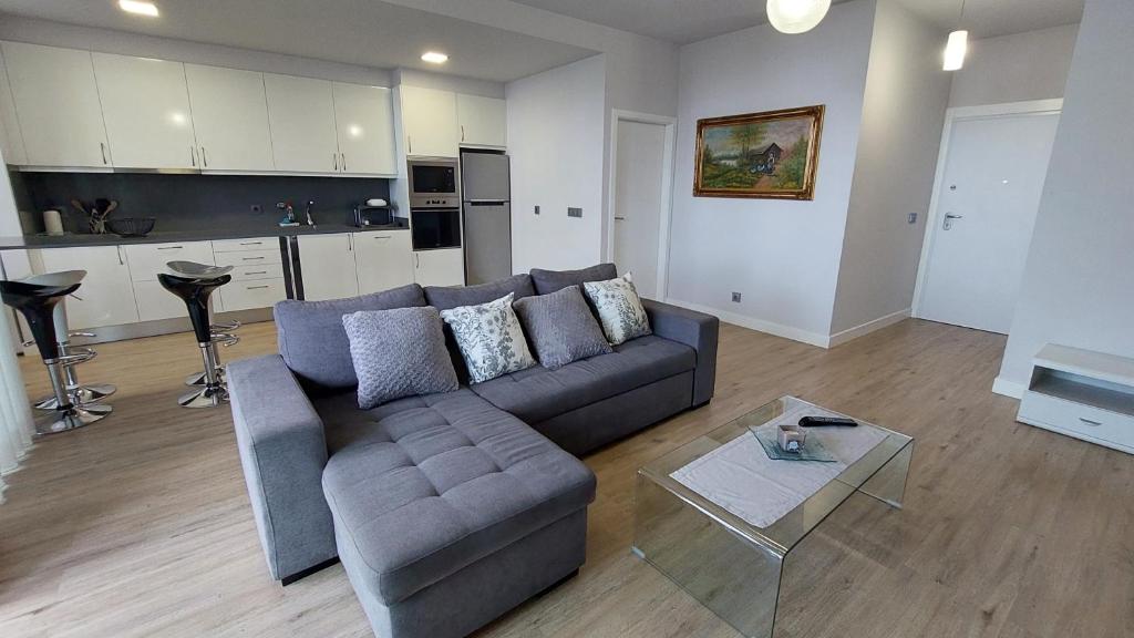 een woonkamer met een bank en een tafel bij Sol do Til Apartment in Funchal