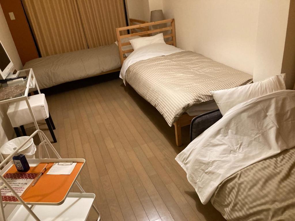 Habitación pequeña con 2 camas y mesa. en Sudomari Akariya - Vacation STAY 68896v, en Tanabe