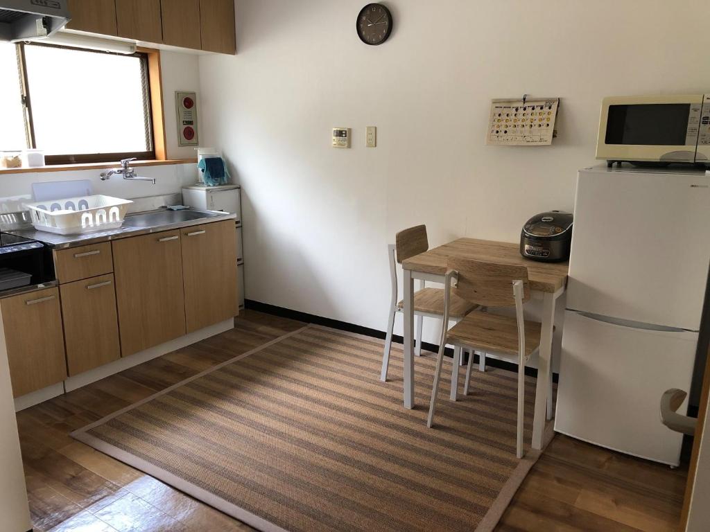 a small kitchen with a table and a refrigerator at Guesthouse & Kitchen Hace - Vacation STAY 68911v in Iwaki
