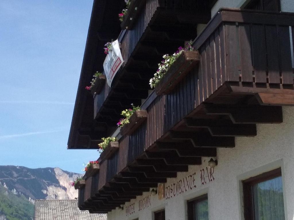 a building with a balcony with flowers on it at Hotel Mignon in Folgaria