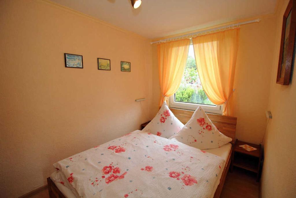 Un dormitorio con una cama blanca con flores. en Ferienhaus Frisch, en Sassnitz