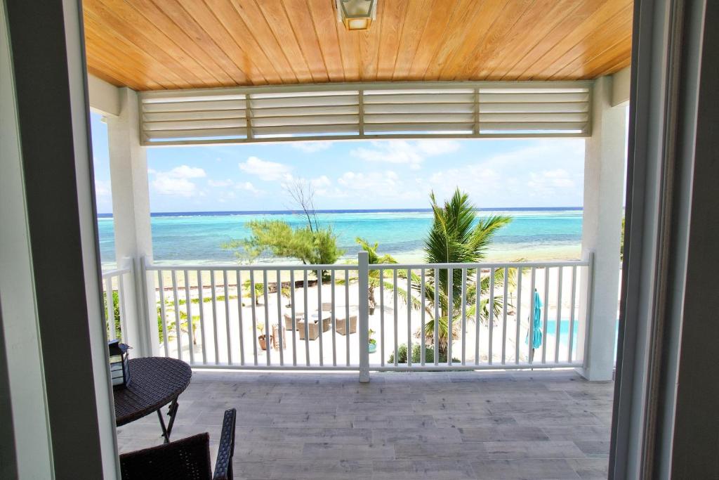 a room with a view of the ocean from a balcony at The Blue Iguana at Cottages in Sand Bluff