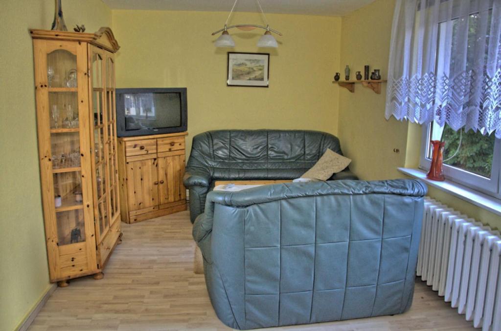 een woonkamer met een leren bank en een televisie bij Ferienwohnung Karger in Marlow