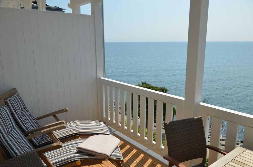 a balcony with two chairs and a table and the ocean at Fürstenhof - Ferienwohnung 203 in Sassnitz