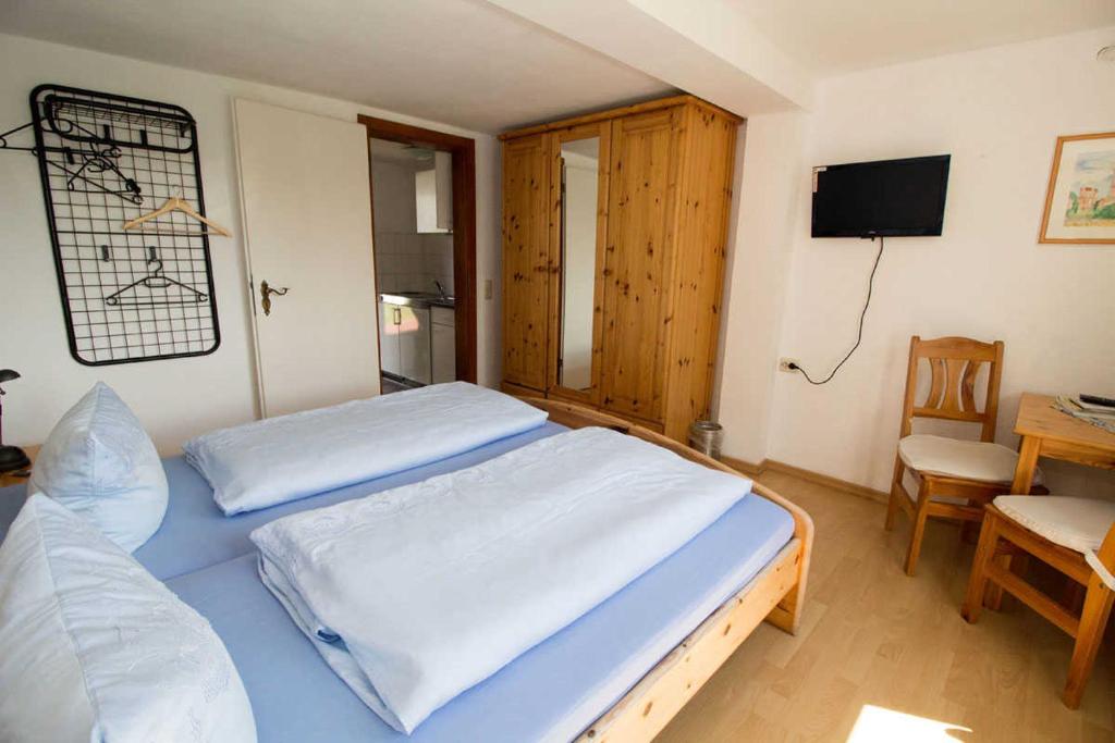 1 Schlafzimmer mit 2 Betten, einem Tisch und einem TV in der Unterkunft Ferienzimmer zum Försterberg in Hagen