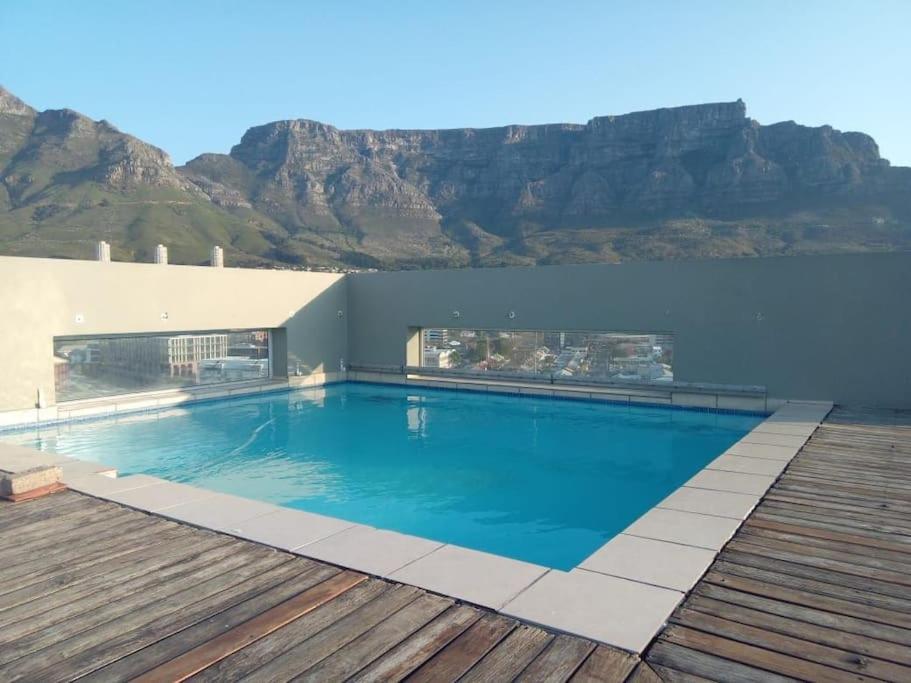 a swimming pool with a mountain in the background at Perspectives on Roeland in Cape Town