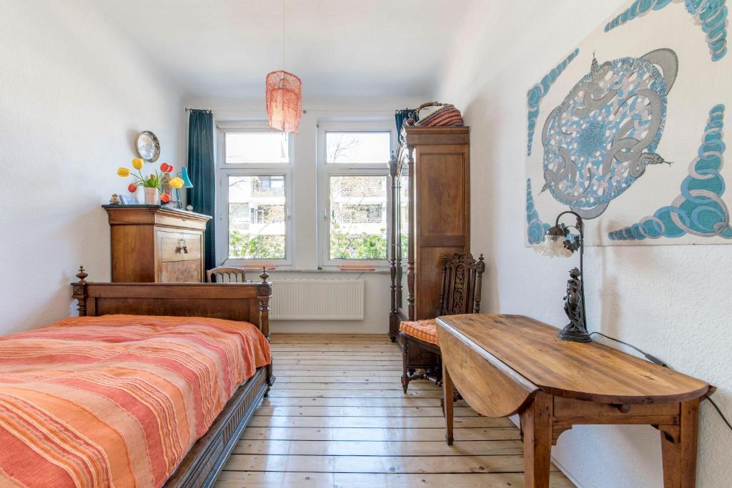 a bedroom with a bed and a table and a window at Private Rooms in Hannover