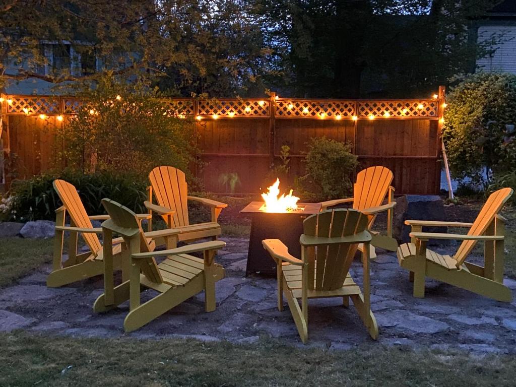 a group of chairs sitting around a table with a fire at Steps to the Waterfront in Shelburne