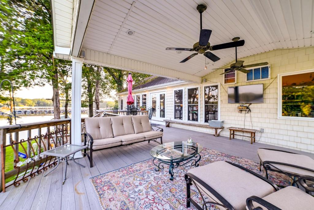 een veranda met een bank en stoelen en een tv bij Pet-Friendly New Concord Vacation Rental on Lake! in New Concord