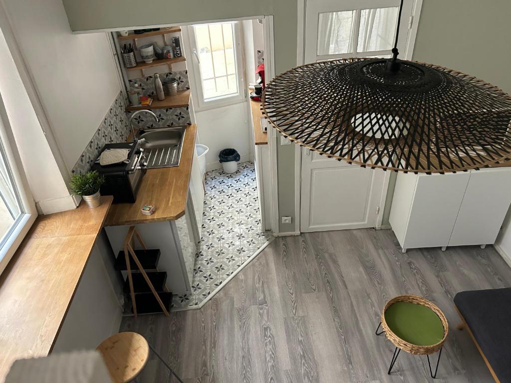 - une vue de tête sur une cuisine dotée d'un lustre dans l'établissement Lovely studio Crimee, à Paris