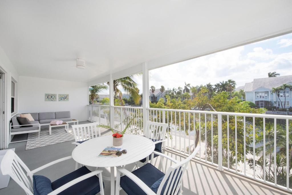 a white balcony with a white table and chairs at Snug Harbour View Condo #8 in George Town