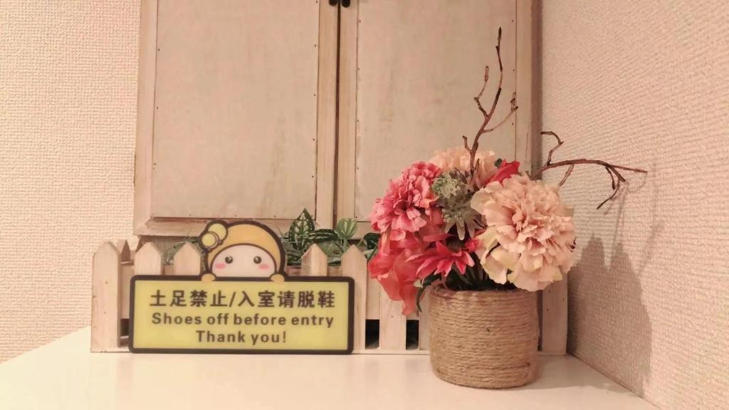 a vase with flowers on a shelf next to a sign at Jing House Koiwa - Vacation STAY 63200v in Tokyo