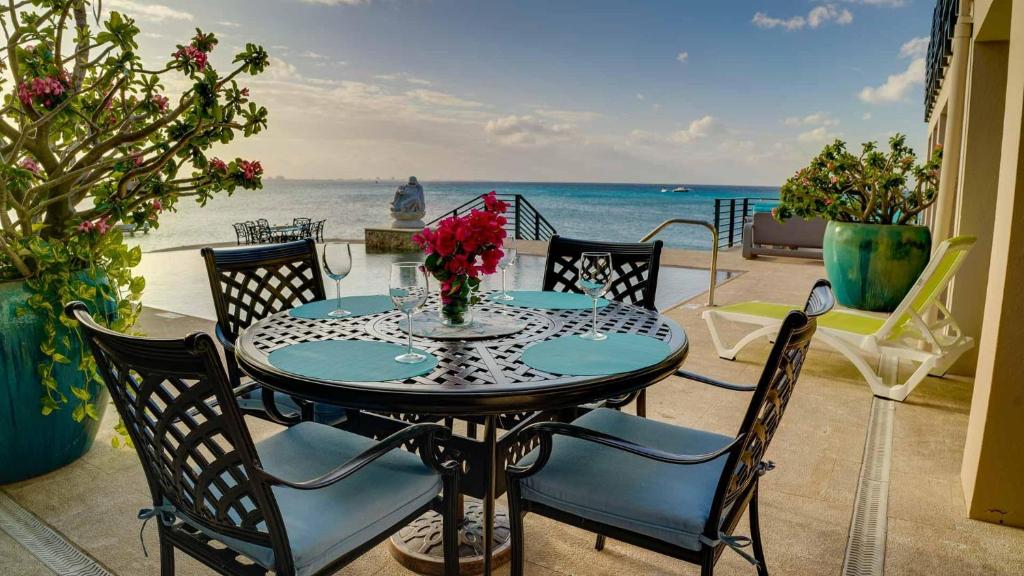 stół i krzesła z widokiem na ocean w obiekcie Seven Mile View Condo #2 w mieście West Bay