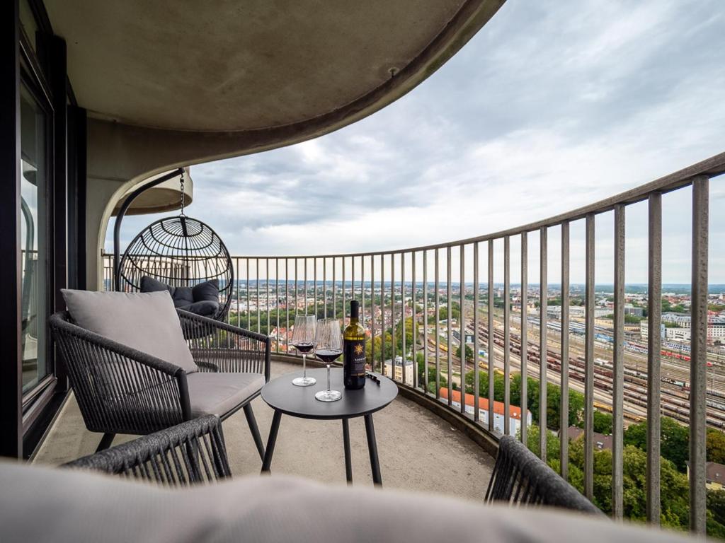 einen Balkon mit einem Tisch und einer Flasche Wein in der Unterkunft Hotel Tower I 26th floor I Boxspring I Nespresso in Augsburg