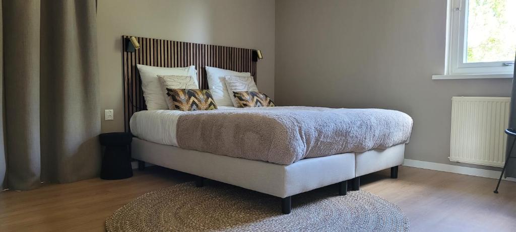Un dormitorio con una cama con almohadas. en Vakantiewoning Meerssen Valkenburg Maastricht en Meerssen