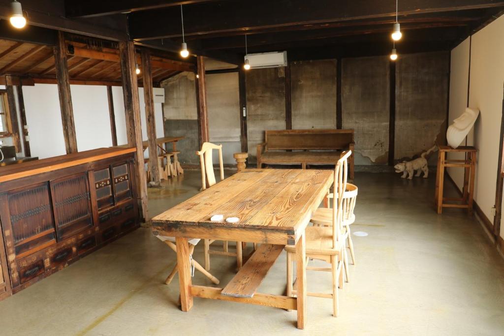 um quarto com uma mesa de madeira e cadeiras em Womb Guesthouse Kojima -Uminomieru ie- - Vacation STAY 95107v em Tamano