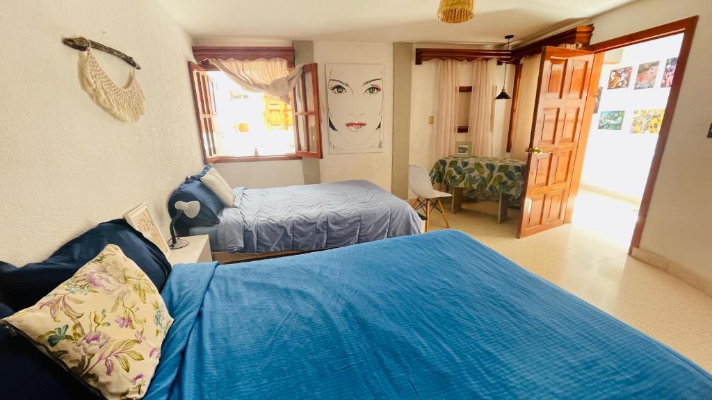 um quarto de hotel com duas camas e um quarto com em Casa Nazimova Blue Room em San Cristóbal de Las Casas