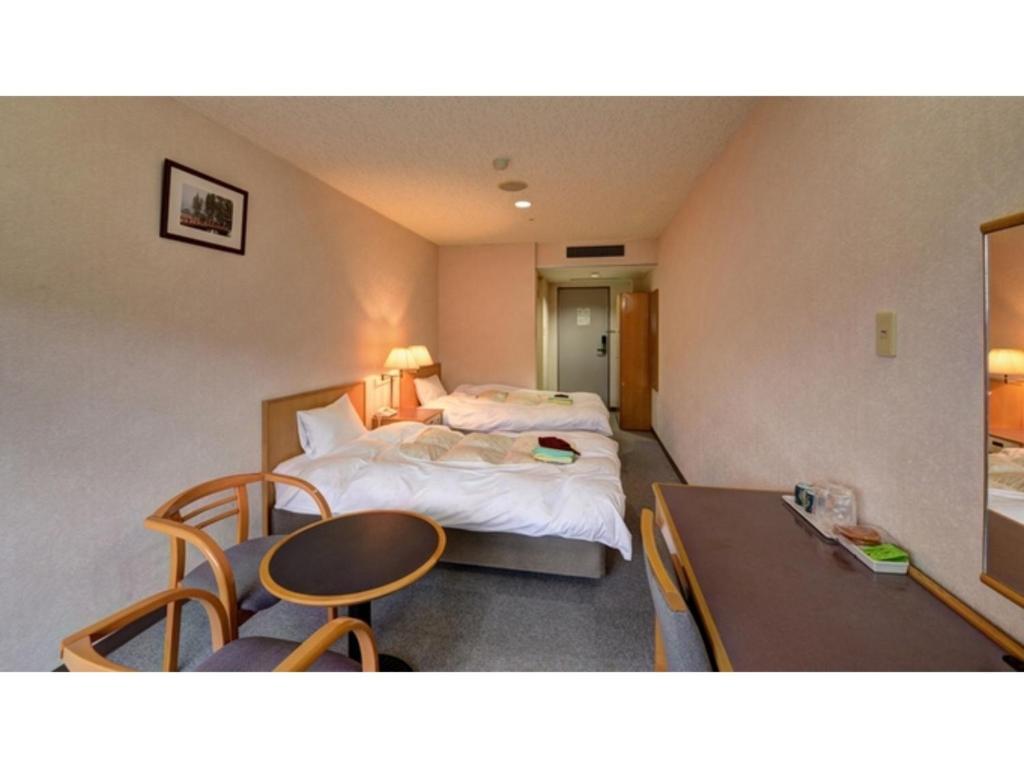 松江市にあるYuuai Kumanokan - Vacation STAY 27598vのベッド2台とテーブルが備わるホテルルームです。