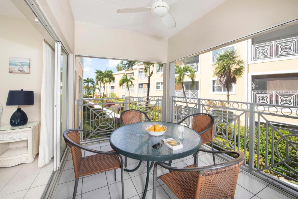 patio con mesa y sillas en el balcón en Regal Beach Club #322, en George Town