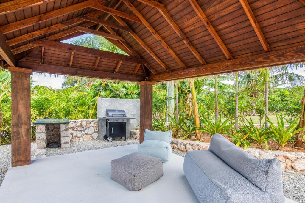 a patio with a couch and chairs and a fireplace at The Mastic Cana Luxury Cottage in North Side