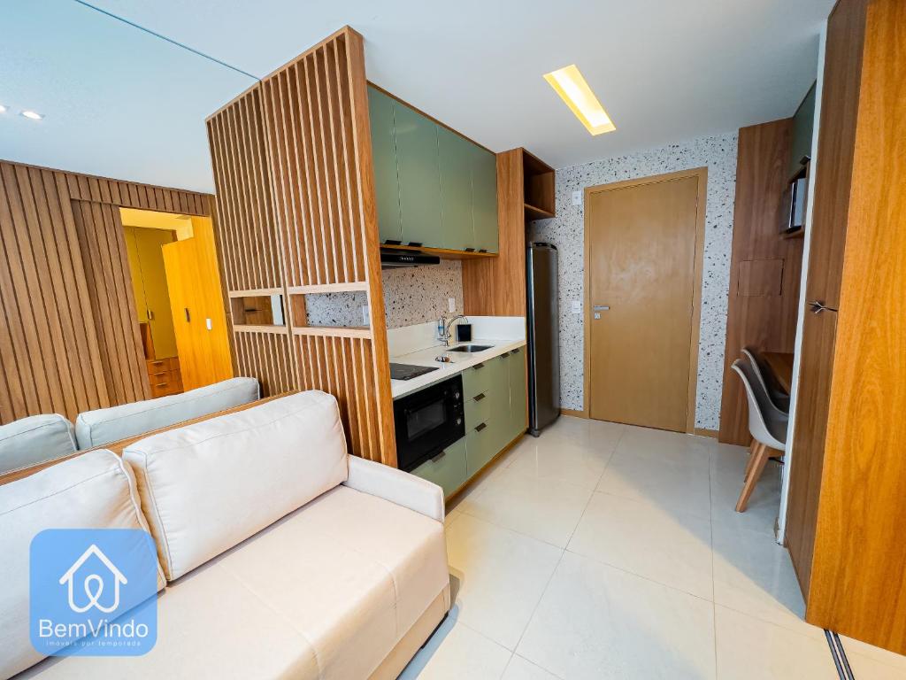 sala de estar con sofá y cocina en Apartamento de alto padrão no Caminho das Arvores, en Salvador