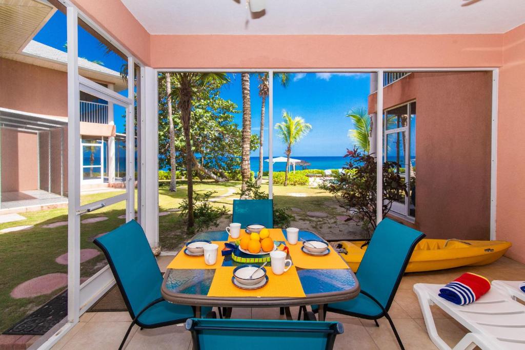 a dining room with a table and chairs and the ocean at Northern Lights #4 Condo in Old Man Bay