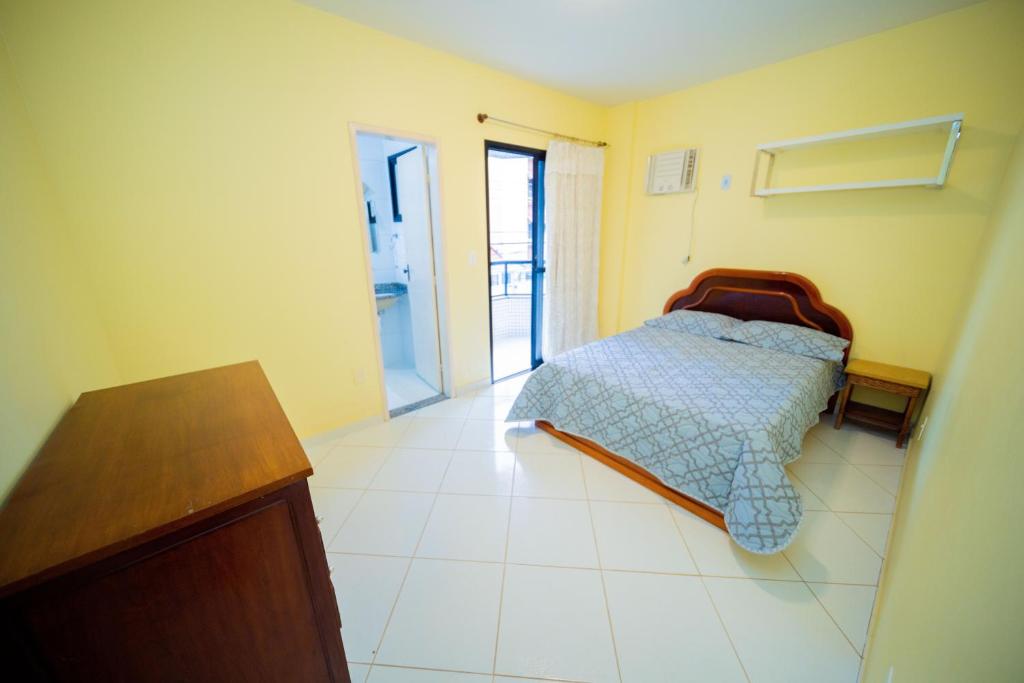 um quarto com uma cama e uma cómoda em Joao Meira Apartments em Guarapari