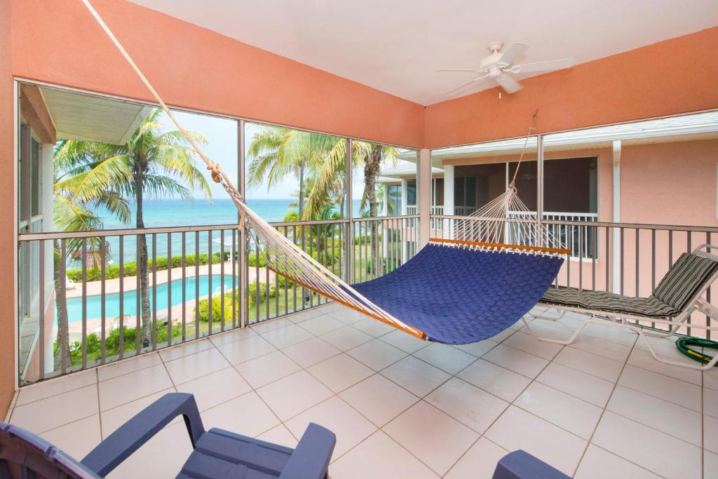 a hammock on a balcony with a view of the ocean at Northern Lights #6 Condo in Old Man Bay