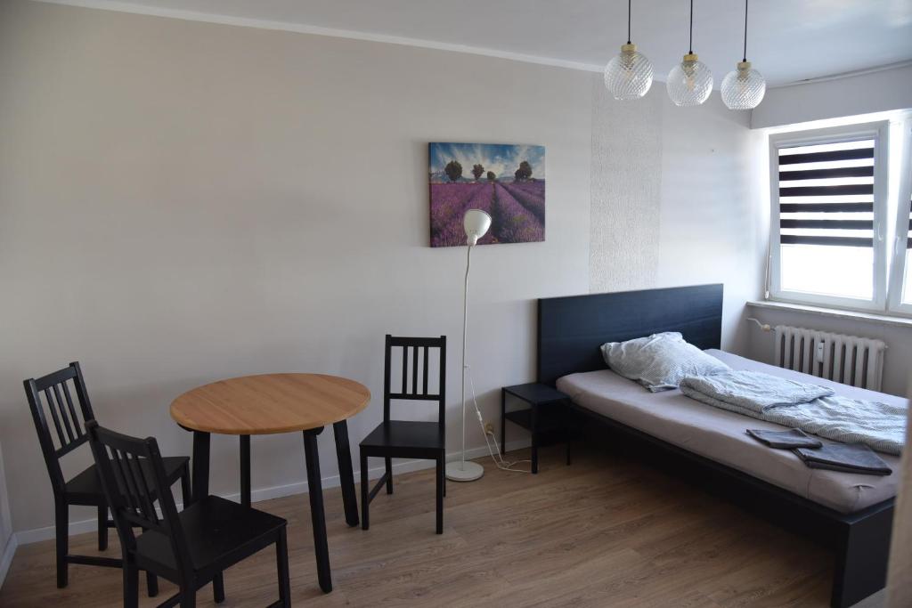 sypialnia z łóżkiem, stołem i krzesłami w obiekcie Kawalerka Górnośląska w Kaliszu